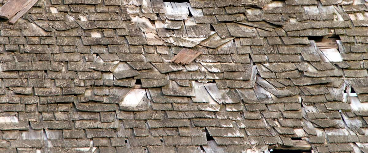 Wood shake shingle roof more then 30 years old decaying and falling apart. Exceeded life expectancy, damaged by wind and rain, needs to be replaced. Storm damaged