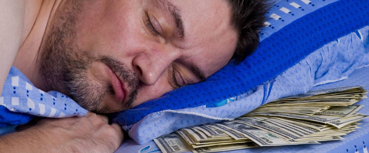 man sleeping with money under his pillow