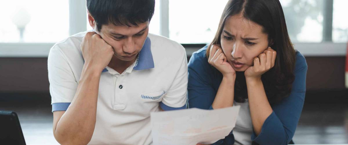 Family financial crisis concept. Stressed couple calculating credit card debt.