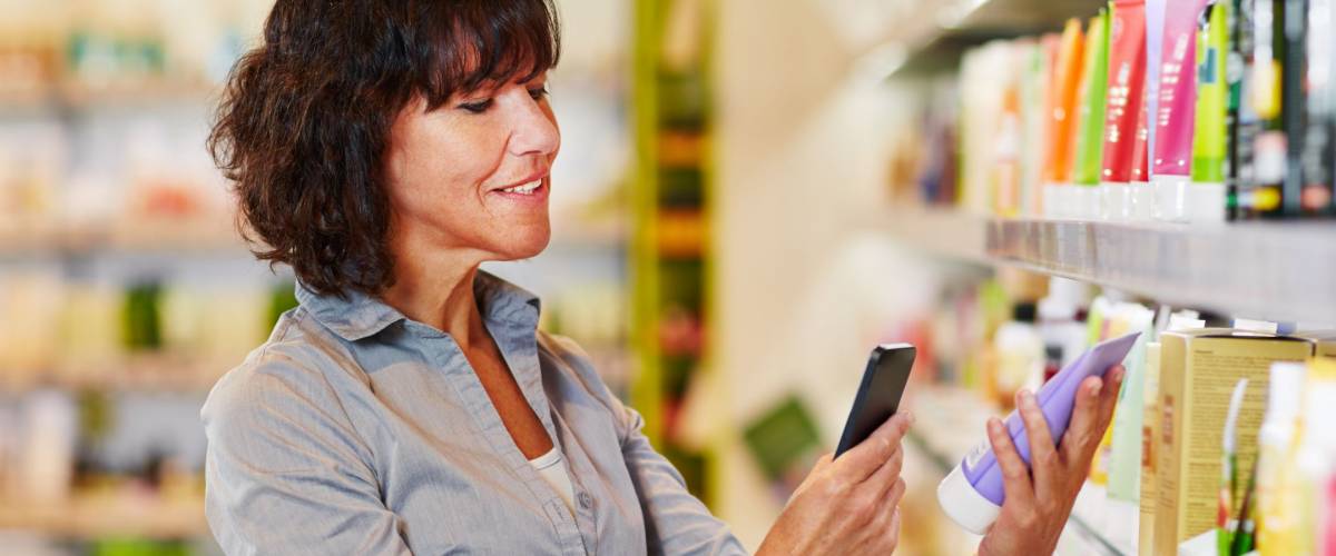 Elderly woman scanning barcode of cosmetics product in a drugstore