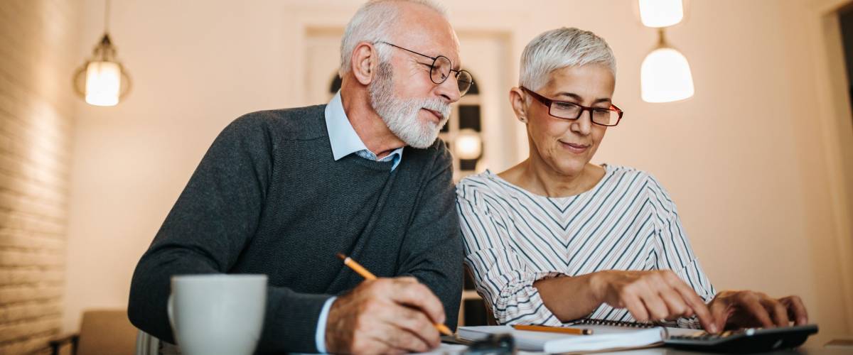 Mature couple doing some paperwork and calculations at home