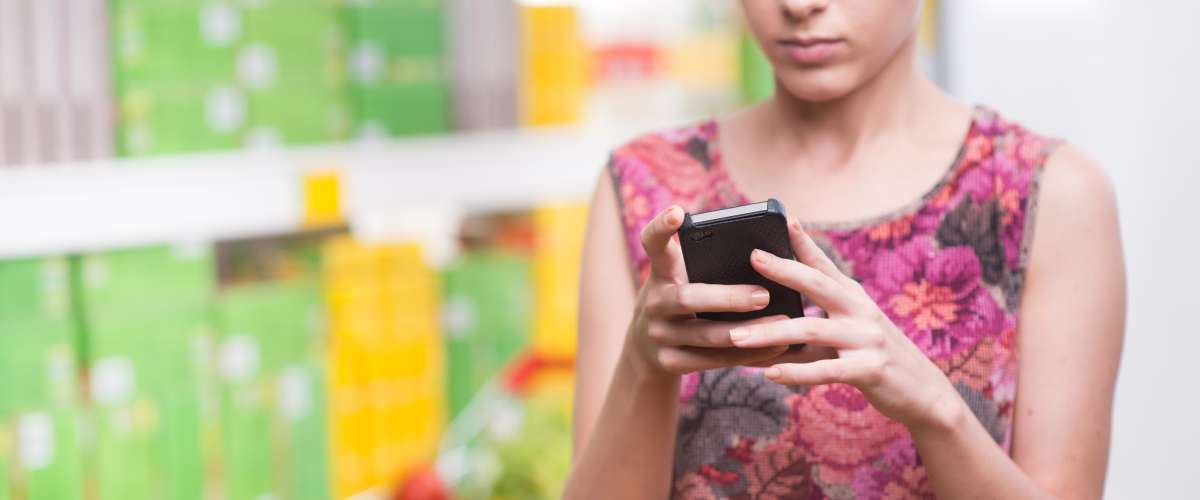 woman using phone to check price in store