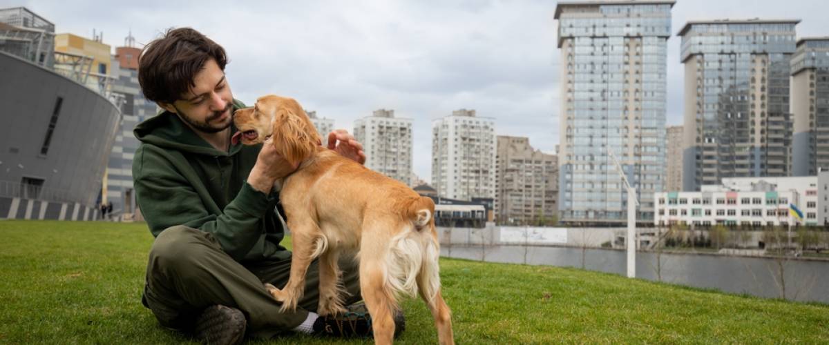 Man sitting with dog in grass