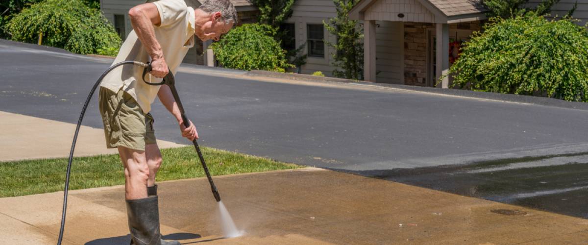 Man power washing driveway