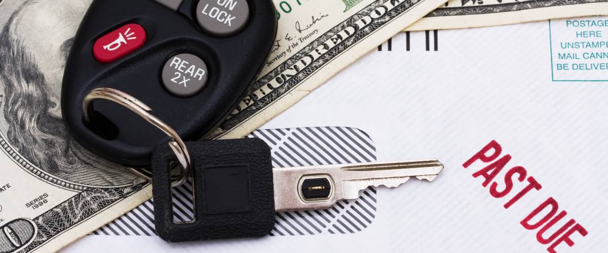 Past due bills splayed out next to cash and car keys