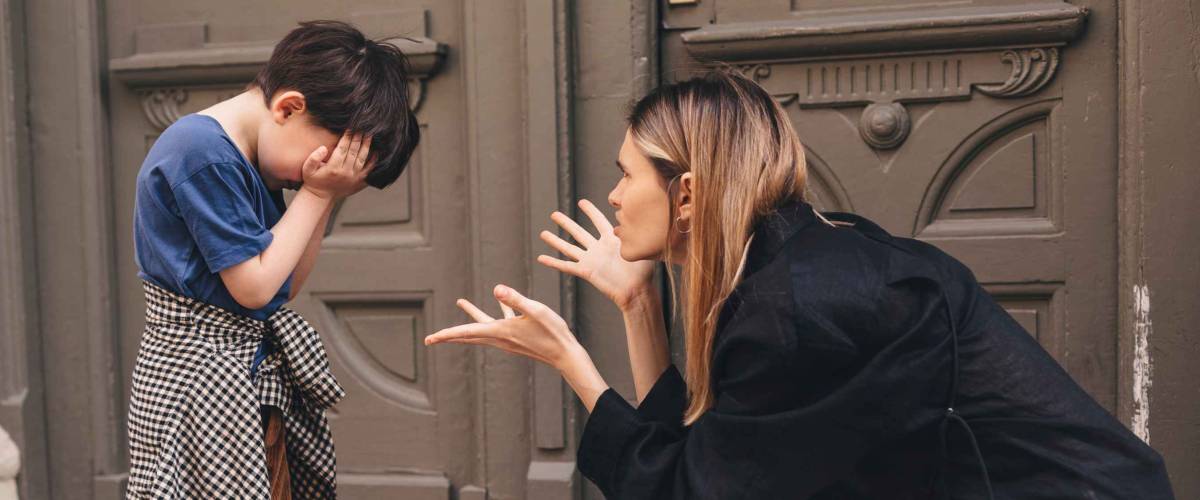 Mother scolds her son on the street.