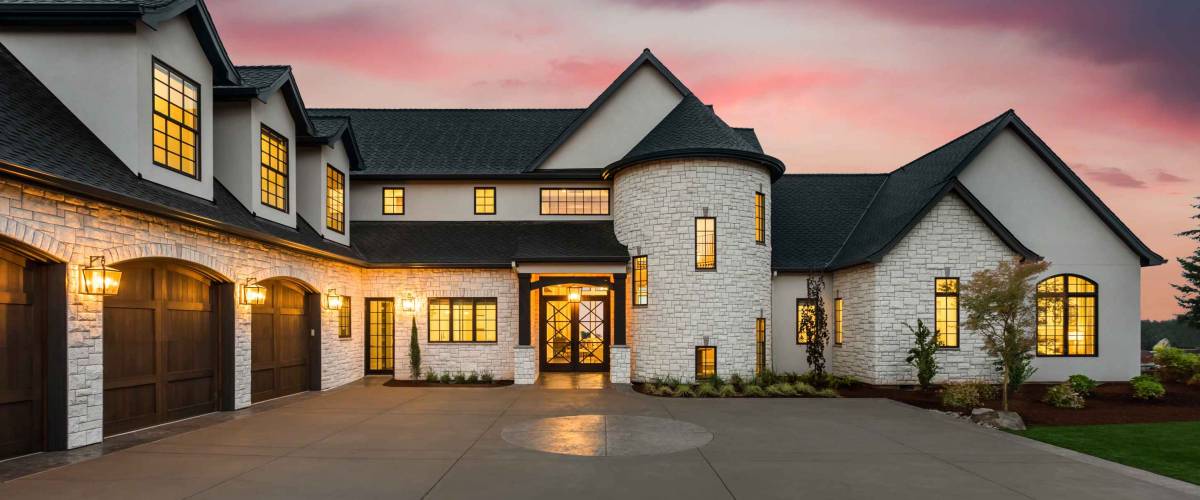 Beautiful Luxury Home Exterior at Twilight with Colorful Sunset Sky