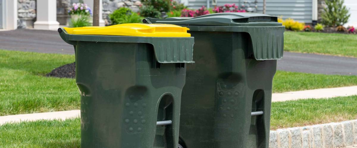 big empty green plastic trash garbage bin in front of the modern house junk road public