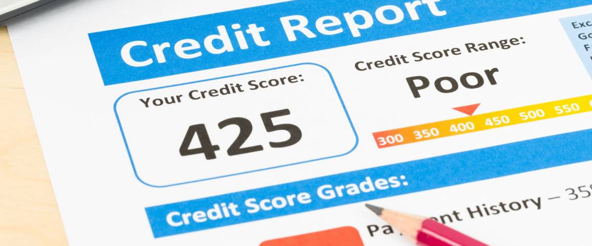 Poor credit score report with pen and calculator