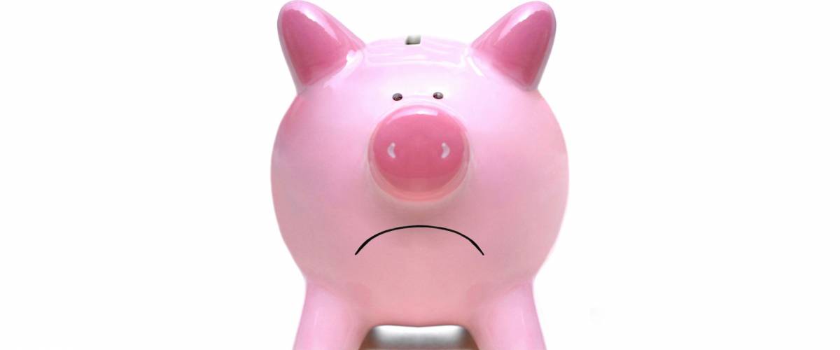 Sad pink piggy bank closeup isolated