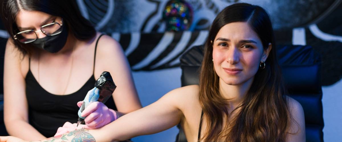Woman getting tattoo on her arm