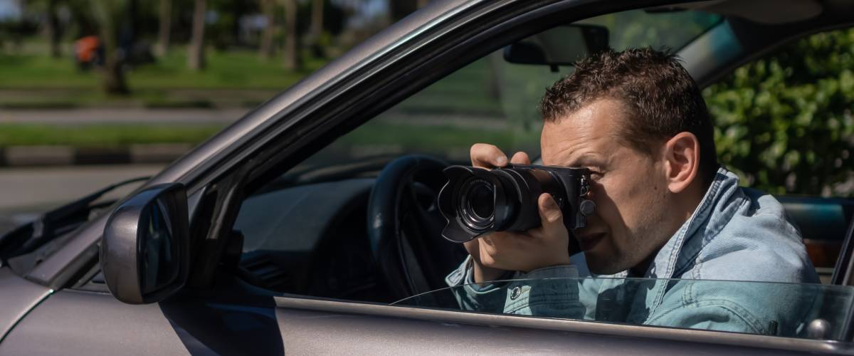Man stalking and taking photos from car