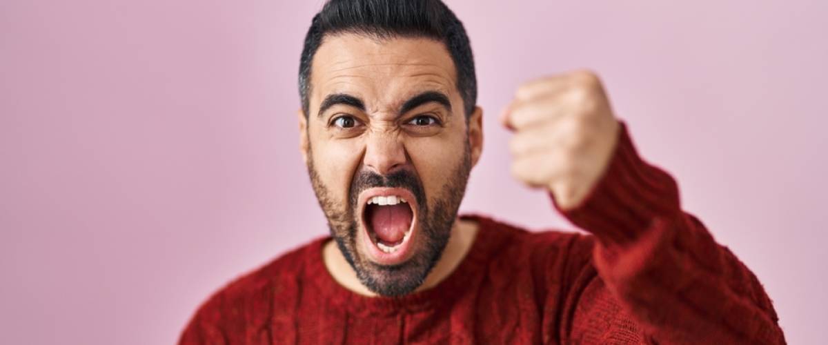Man looking angry and raising his fist while yelling