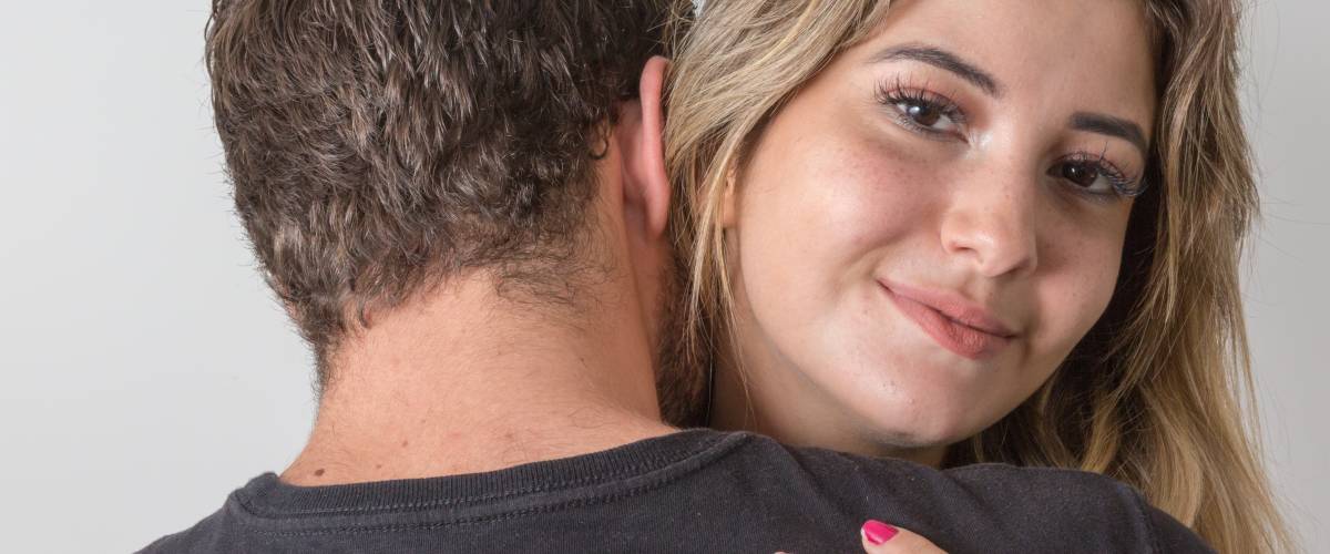 Woman hugging man very tightly and smiling