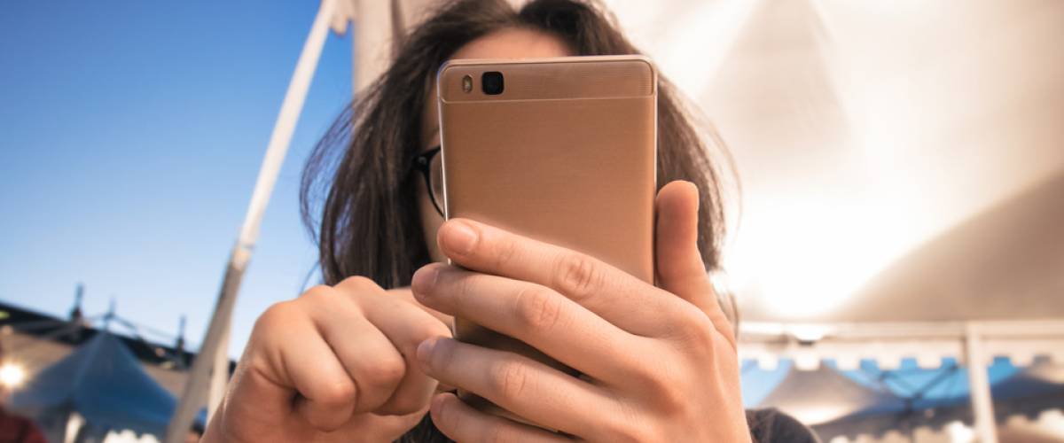 Woman holding her phone up to her face at restaurant