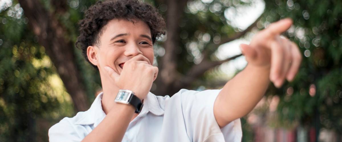Young man pointing and laughing