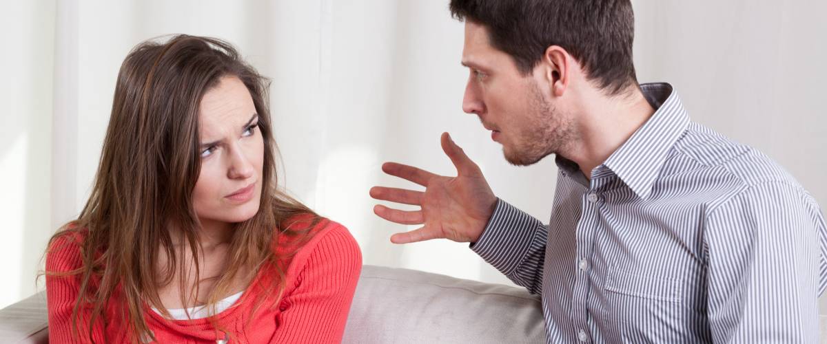 Man yelling at woman on couch