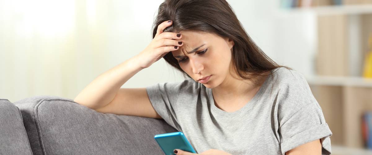 Woman concernedly looking at her phone
