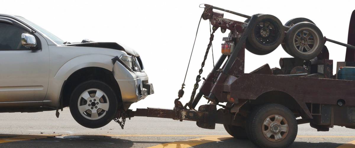 Tow truck delivers the damaged vehicle isolated on white background, with clipping path