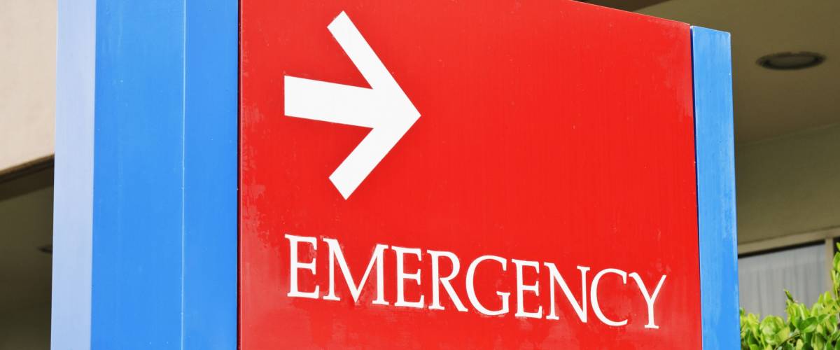 sign at the hospital points towards the emergency room entrance.
