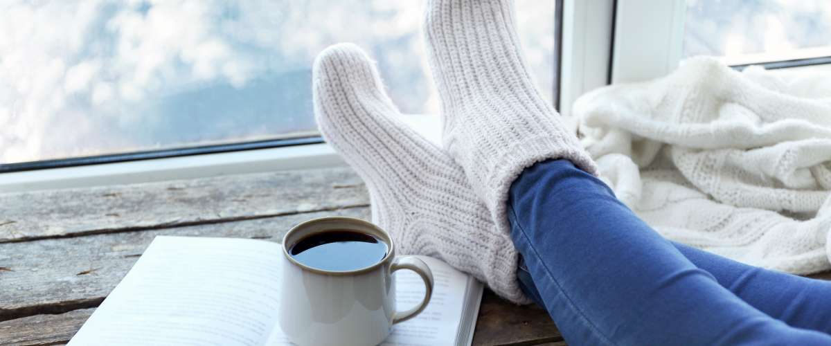cozy knit socks hot drink book on window sill