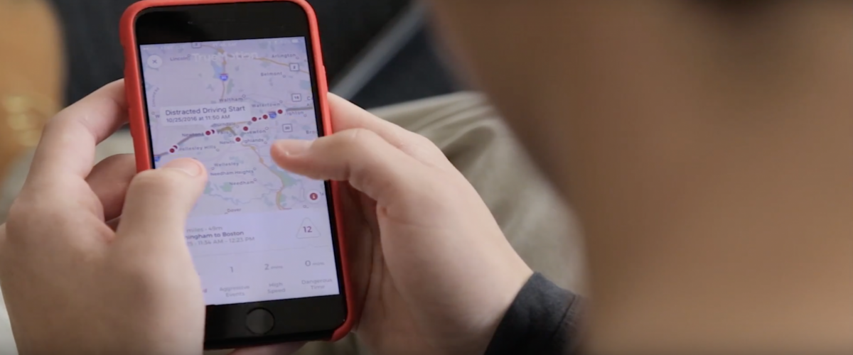 Teenager reviews his driving score, provided by the TrueMotion app.