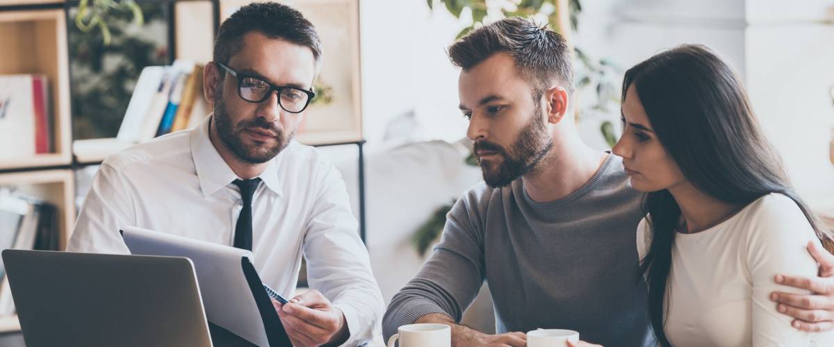 Couple holding coffee seeks advice from an auto insurance professional