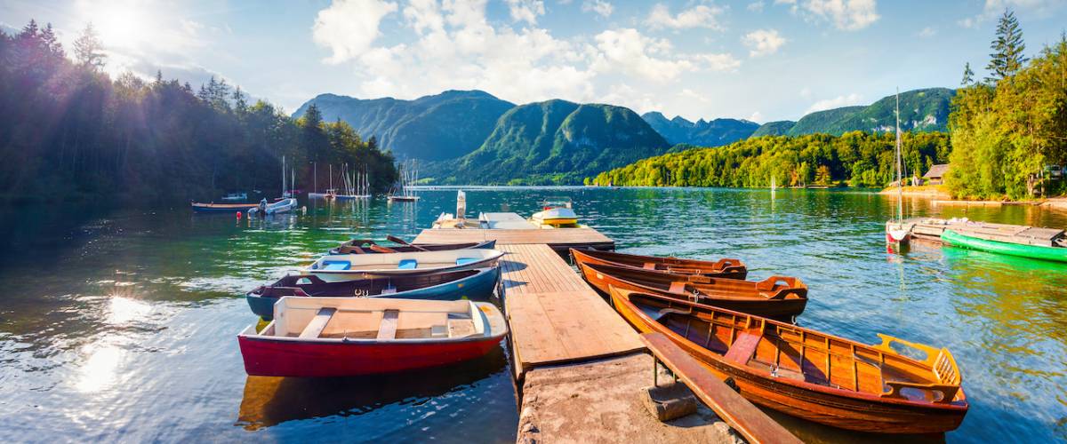 Colorful summer panorama of the Bohinj Lake. Picturesque moning scene in the Triglav National Park, Julian Alps, Slovenia. Popular tourist leisure on the boat. Artistic style post processed photo.