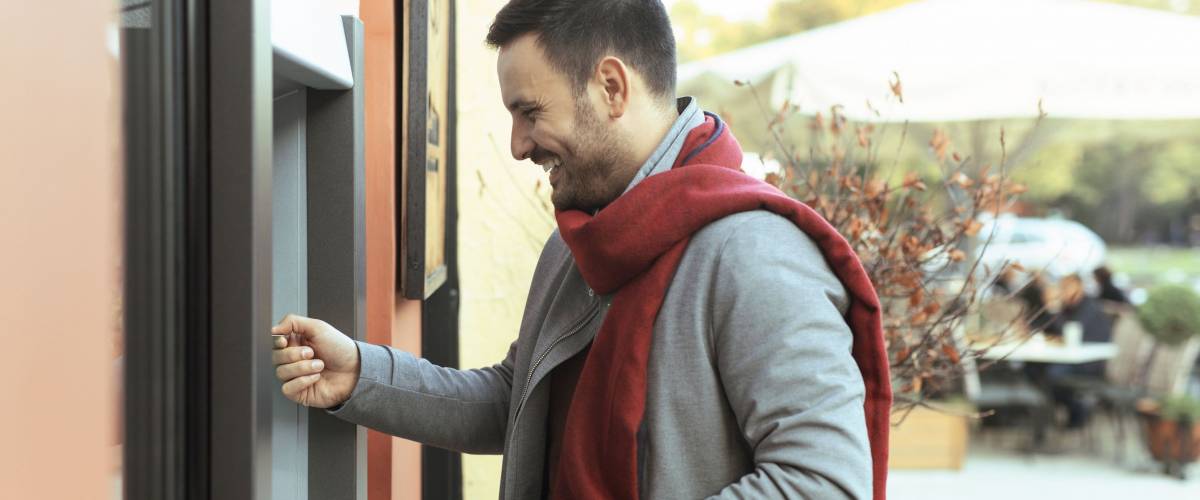 Handsome man taking money from the ATM