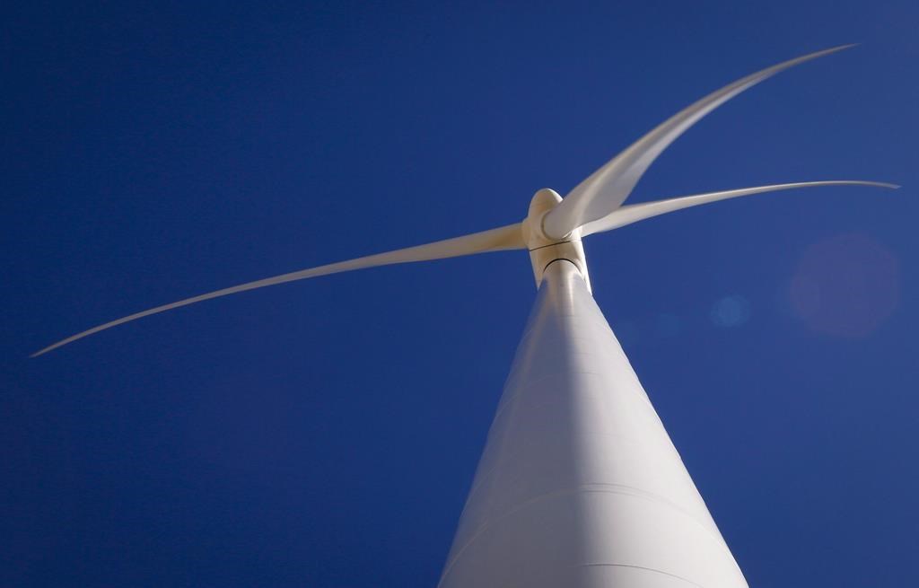A new report says if high interest rates persist, it will be harder and more costly for society to transition to a net-zero economy. A wind turbine is shown at a wind farm near Pincher Creek,