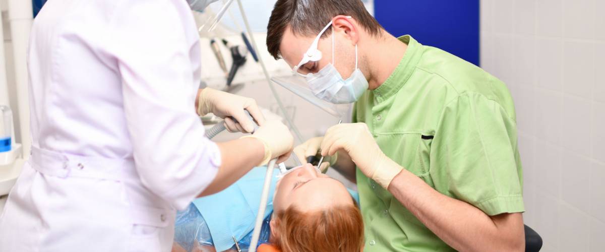 Dentist starting common operation of cleaning female mouth in the dentists office