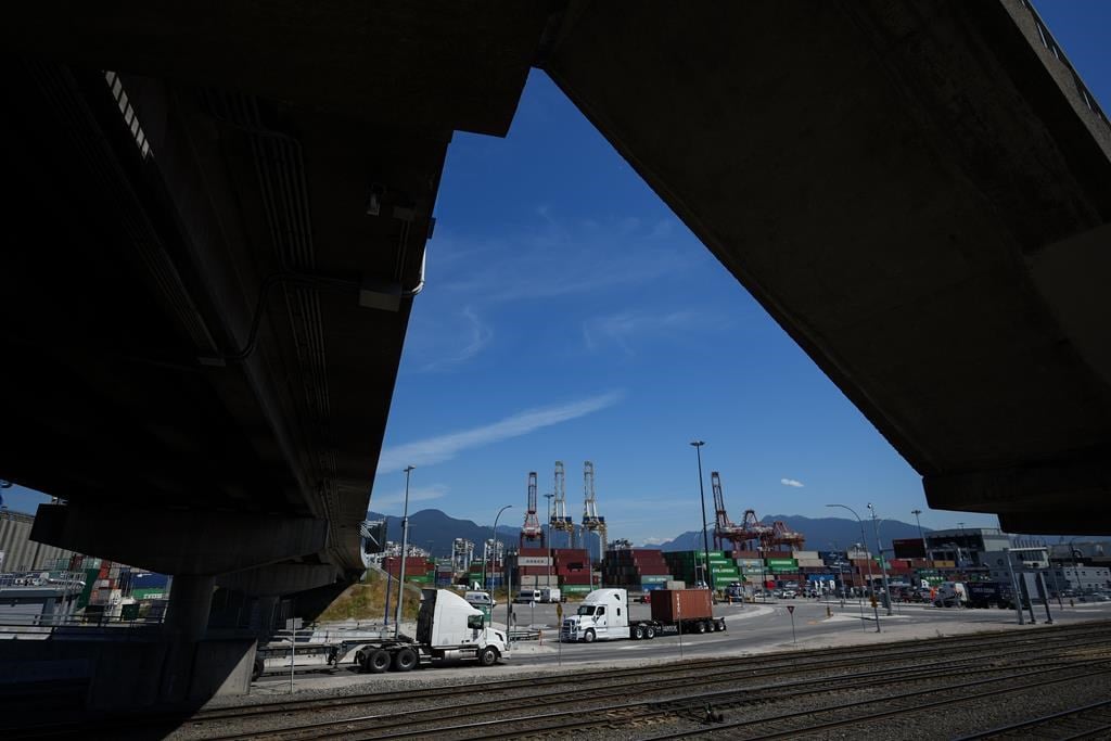 The head of Canada&#039;s biggest trucking firm says the U.S. election is softening an already weak market for freight. A transport truck carries a cargo container at port in Vancouver, on Friday,