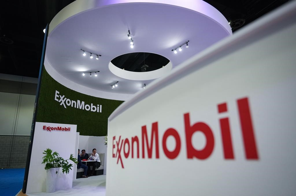 Delegates meet at the Exxon Mobil booth during the LNG2023 conference, in Vancouver on July 11, 2023. 