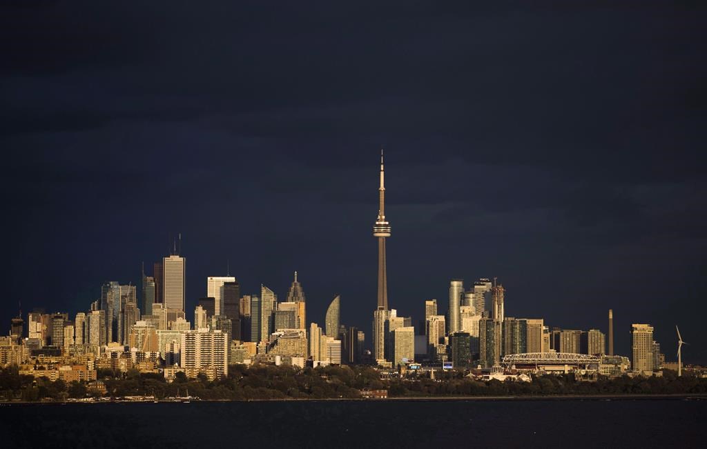 Light from the sunset hits the skyline in Toronto on October 31, 2017. 