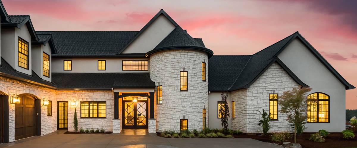 Beautiful Luxury Home Exterior at Twilight with Colorful Sunset Sky