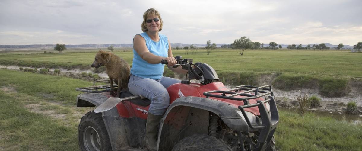 Woman-farmer on ATV 4-wheel drive in Western Nebraska near Chimney Rock, Nebraska