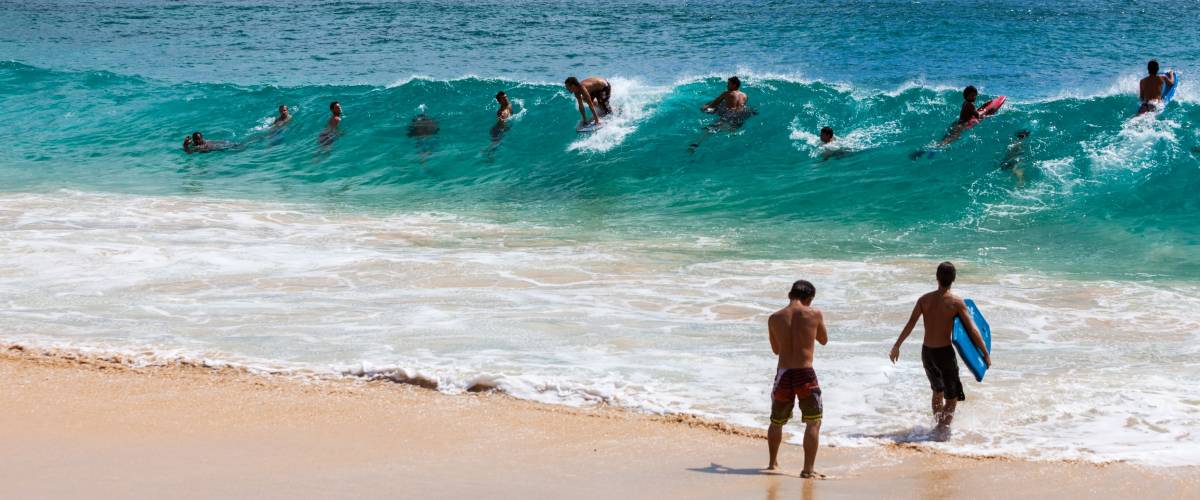 Unidentified surfers and body surfers at Sandy Beach on Oahu Island, Hawaii, USA, circa October 2013