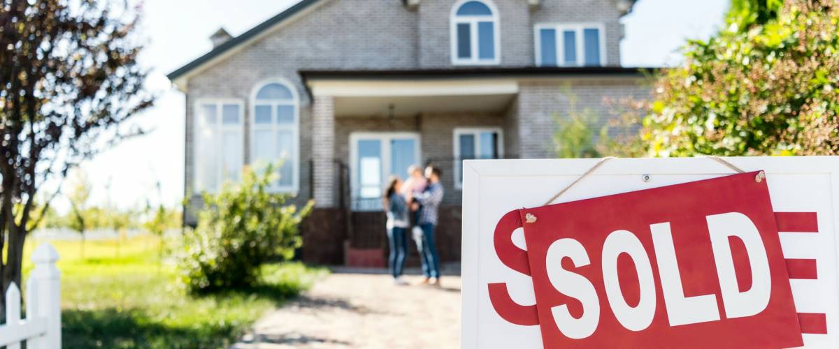 sold house with blurred family on background