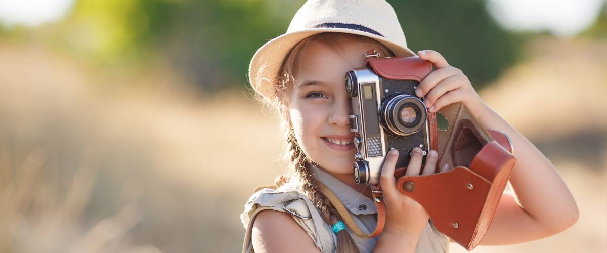 little girl holding old analog camera