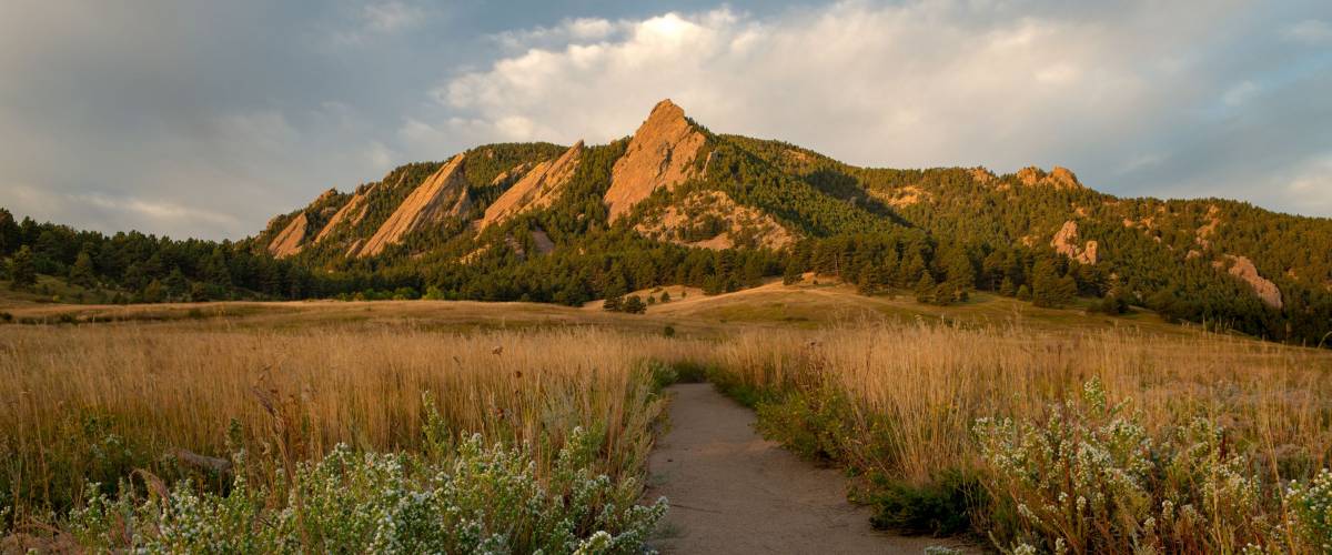 A hiking path leads to the Flatiron Mountains and adventure in Boulder Colorado's Chautauqua Park.