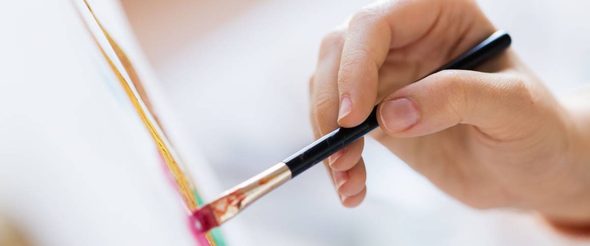 hand of artist with brush painting picture