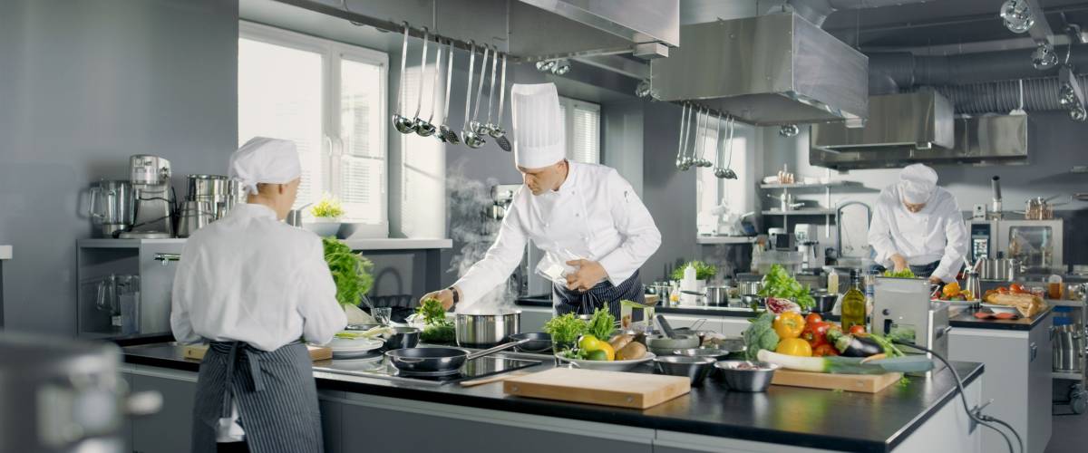 restaurant kitchen with three male chefs