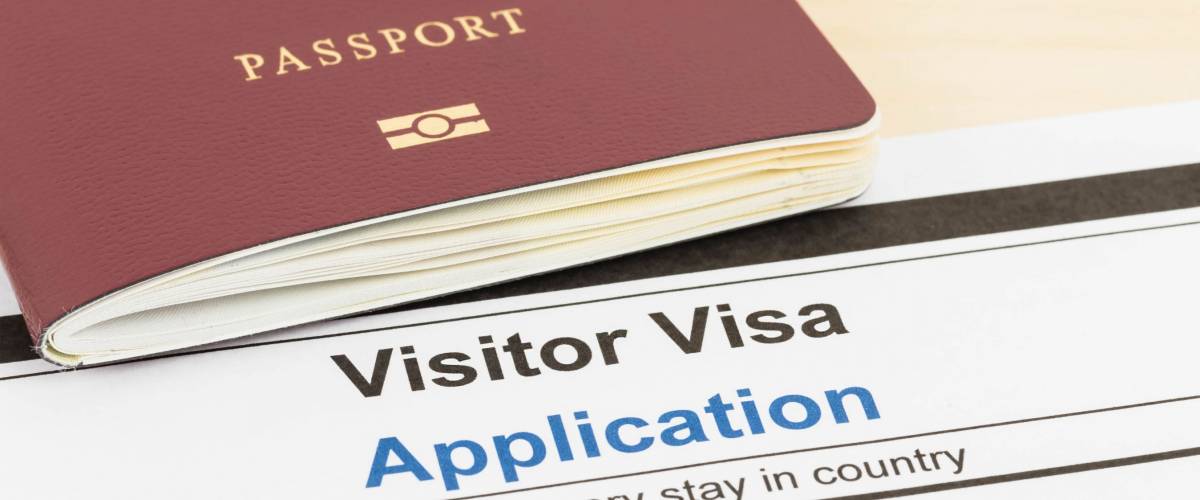 Visa application form with passport and pen