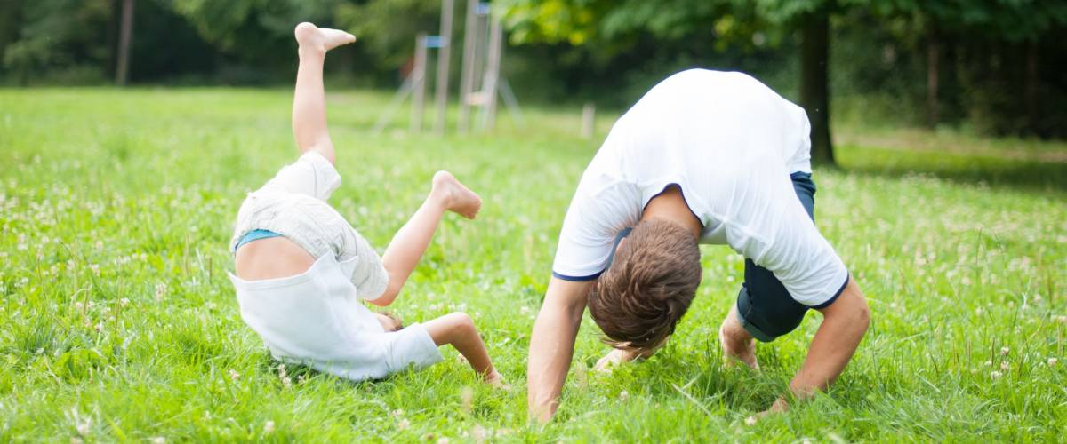 Father and son somersaulting on the ground