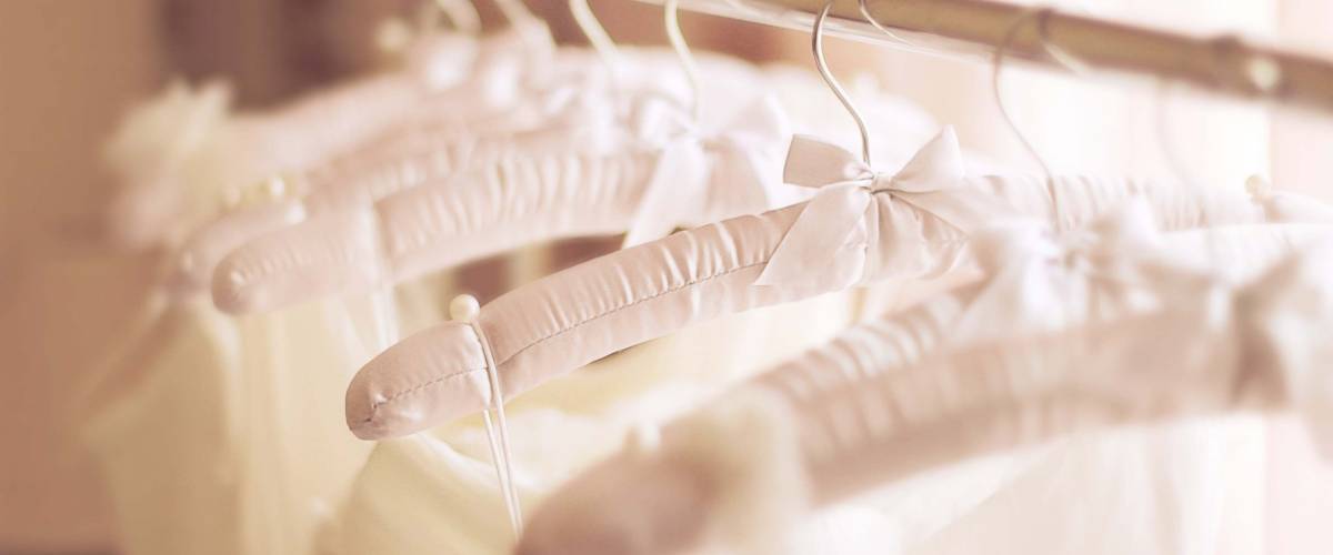 cream and white wedding gowns on hangers