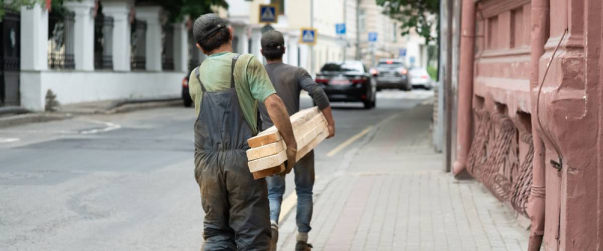 day laborers moving plywood