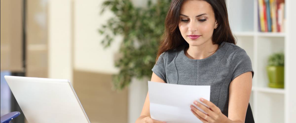 woman reading a letter at her desk