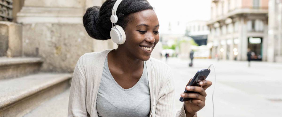 Black woman outdoor listening music