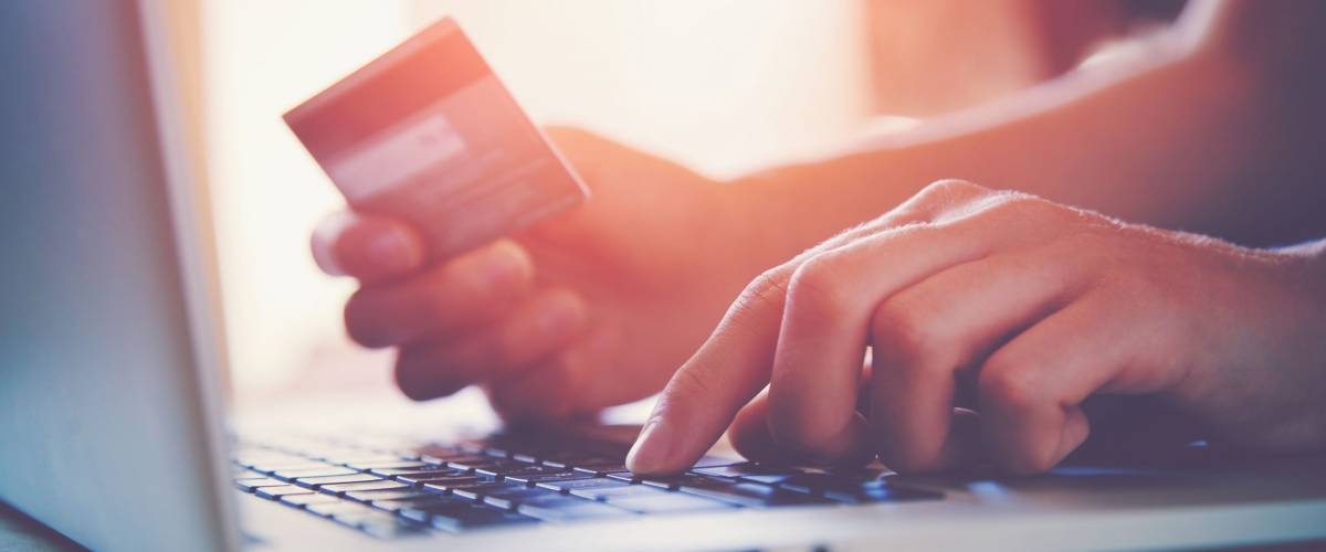 Hands holding credit card and using laptop. Online shopping