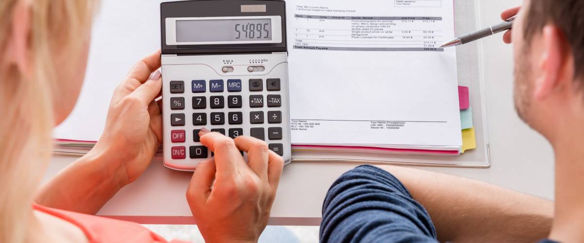High Angle View Of Couple Calculating Invoice, Taxes And Family Budget At Home